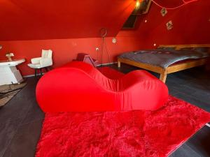 a large red heart shaped ottoman in a room at Intimissima apartman in Odorheiu Secuiesc