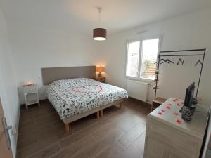 a small bedroom with a bed and a window at Gîte du Bois de Drancourt in Drancourt