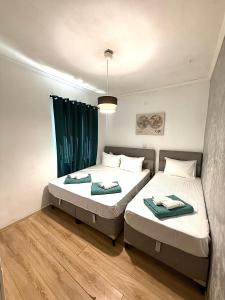 two beds in a room with green curtains at Apartman VUKAN in Budva