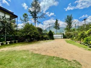 an empty yard with trees and a building at Elegant Mist Villa in Nuwara Eliya