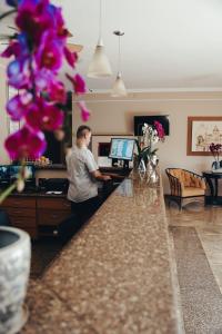 a man standing at a counter with a computer at Candeias Hotel in Batatais