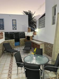 a patio with a table and chairs and a fireplace at C&M Dream House in Morro del Jable
