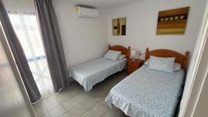 a room with two beds and a window at C&M Dream House in Morro del Jable