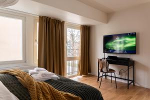 a bedroom with a tv and a bed with a chair at Guestly Homes - Central Smart Studio in Västerås