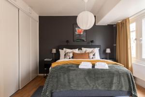 a bedroom with a large bed with a black wall at Guestly Homes - Central Smart Studio in Västerås