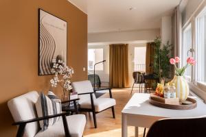 a living room with a table and chairs at Guestly Homes - Central Smart Studio in Västerås