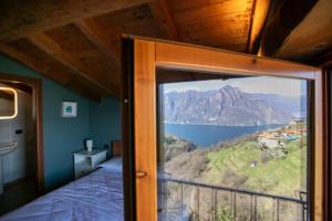 a bedroom with a view of a lake and mountains at Lake Iseo View Retreat - Quiet & Nature in Fonteno +21 photos