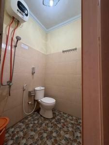 a bathroom with a toilet and a shower at Rumah Ukhi Guest House in Yogyakarta +110 photos