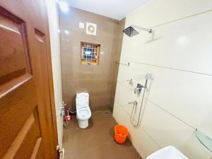 a small bathroom with a toilet and a shower at THE iVORY VILLA in Kottayam