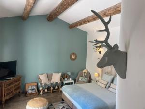 a bedroom with a bed with a deer head on the wall at Côté Dentelles in Vacqueyras