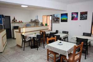 a restaurant with tables and chairs and a kitchen at Villa Mefaja in Krujë