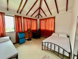 a bedroom with two beds and a tv in it at Elegant Mist Villa in Nuwara Eliya