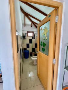 a bathroom with a toilet and a door open at Elegant Mist Villa in Nuwara Eliya +57 photos