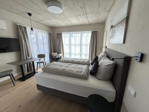 a bedroom with a bed and a desk in a room at Apartotel Berry Hohwacht in Hohwacht
