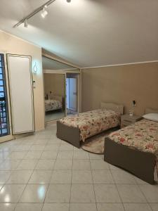 a hotel room with two beds and a bathroom at Cibali rooms in Catania