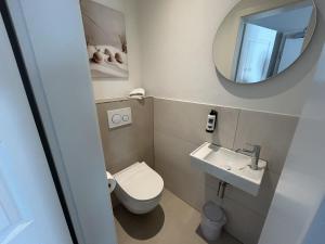 a small bathroom with a toilet and a sink at Apartotel Berry Hohwacht in Hohwacht