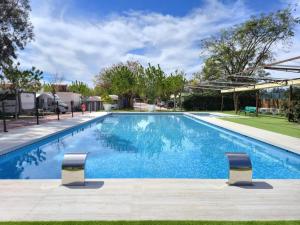 a swimming pool with two chairs in a yard at Camping El Jardín in El Campello