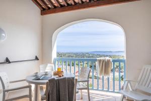 a room with a table and chairs and a balcony at Résidence Pierre & Vacances Les Restanques du Golfe de Saint-Tropez in Grimaud