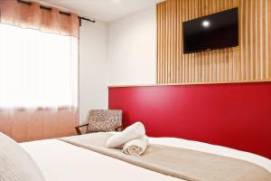 a bedroom with a bed with a red wall at Escale Doullennaise - Appartement neuf avec terrasse in Doullens