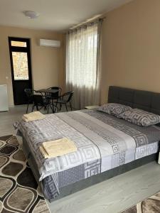 a large bed in a bedroom with a table and chairs at Семеен хотел Струма in Boboshevo +28 photos