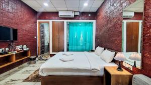 a bedroom with a large bed and a red wall at West Coast Gokarna in Gokarna