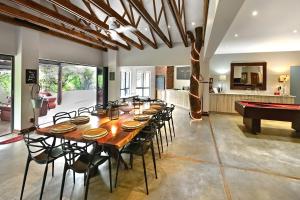 a dining room with a long table and a pool table at Elements Private Golf Reserve 109 in Moheme