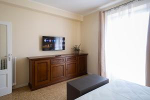 a bedroom with a tv on top of a wooden cabinet at Villa Viadeipini22 in Bellagio