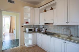 a white kitchen with a sink and a microwave at Villa Viadeipini22 in Bellagio