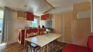 a kitchen with a table with a vase of flowers on it at MOBILE-HOME AC CLIM prox Europapark et Rulantica in Boofzheim