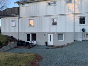 a large white house with a patio in front of it at Hammervatnet Ro in Levanger