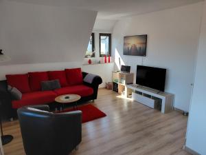 a living room with a red couch and a flat screen tv at Ferienwohnung Twete in Detmold