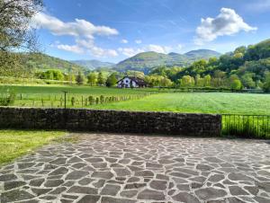 a stone walkway in a field with a house in the background at Casa Rural Mikelenea in Lecároz