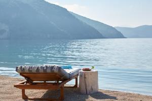 a chaise lounge on the beach next to the water at Lichnos Beach in Parga