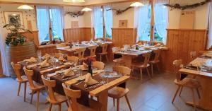 a dining room with wooden tables and chairs at Gasthaus Alpenrose in Innerferrera