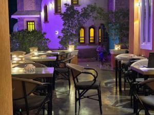 a restaurant with tables and chairs and purple lighting at Tutankhamun Pyramids boutique in Cairo