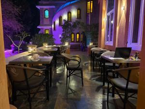 a restaurant with tables and chairs with purple lights at Tutankhamun Pyramids boutique in Cairo +52 photos