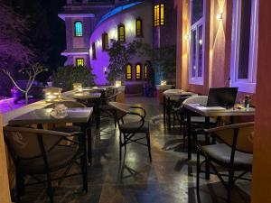 a restaurant with tables and chairs with purple lighting at Tutankhamun Pyramids boutique in Cairo