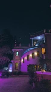 a large house with purple lights on it at night at Tutankhamun Pyramids boutique in Cairo