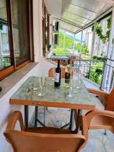 a table with glasses and a bottle of wine on it at Vila Katalea in Gjirokastër