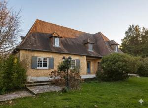 a house with a brown roof on a green yard at Le Clos Périgourdin in Église-Neuve-de-Vergt
