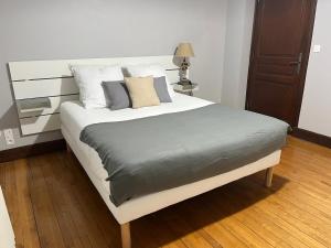 a bedroom with a bed with white sheets and pillows at Le Clos Périgourdin in Église-Neuve-de-Vergt