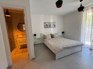 a white bedroom with a bed and a sink at Villa Nika & Eva Valun in Cres