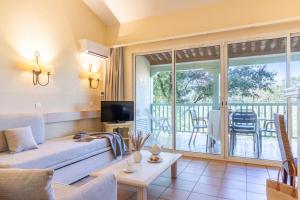 a living room with a couch and a balcony at Résidence Pierre & Vacances Les Restanques du Golfe de Saint-Tropez in Grimaud