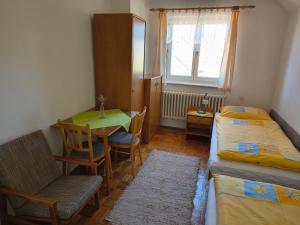 a room with two beds and a table and a chair at Privat Ľubka in Zuberec