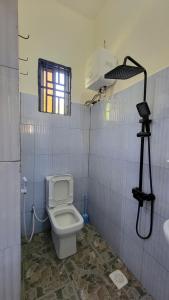 a bathroom with a toilet and a window and a camera at Mamayi Homestay in Mto wa Mbu