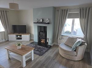 a living room with a chair and a fireplace at Teach Na Dálaigh in Annagry