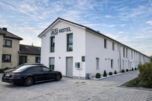 a black car parked in front of a white building at AS-Hotel NOM in Northeim