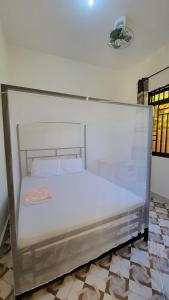 a white bed in a room with at Mamayi Homestay in Mto wa Mbu +22 photos
