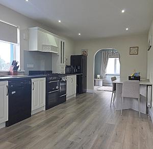 a kitchen with black and white appliances and a table at Teach Na Dálaigh in Annagry