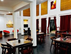 a restaurant with tables and chairs in a room at Amore Beach Resort in Balapitiya